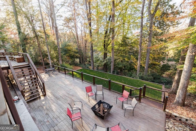 deck with a yard and a fire pit