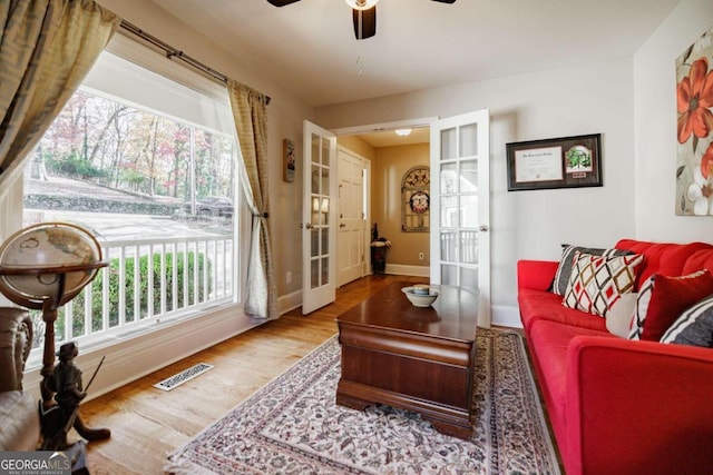 living room with french doors, hardwood / wood-style flooring, and ceiling fan