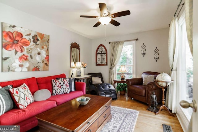 living room with ceiling fan and light wood-type flooring