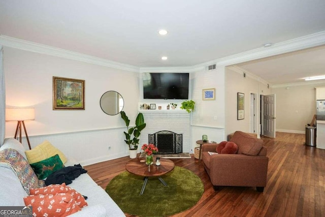 living room featuring a fireplace, wood-type flooring, and crown molding