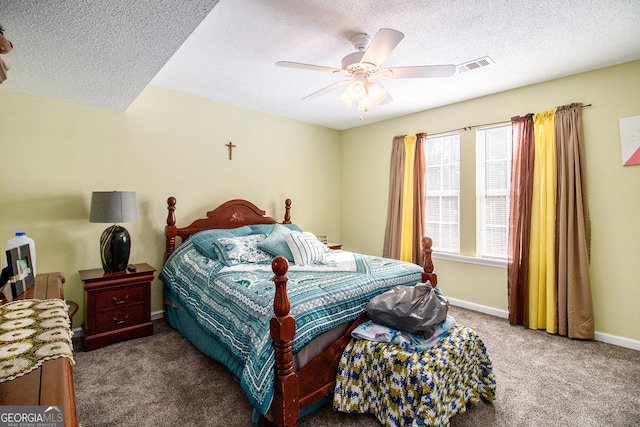 carpeted bedroom featuring ceiling fan and a textured ceiling