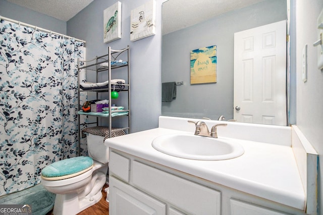 bathroom with wood-type flooring, a textured ceiling, toilet, vanity, and a shower with shower curtain