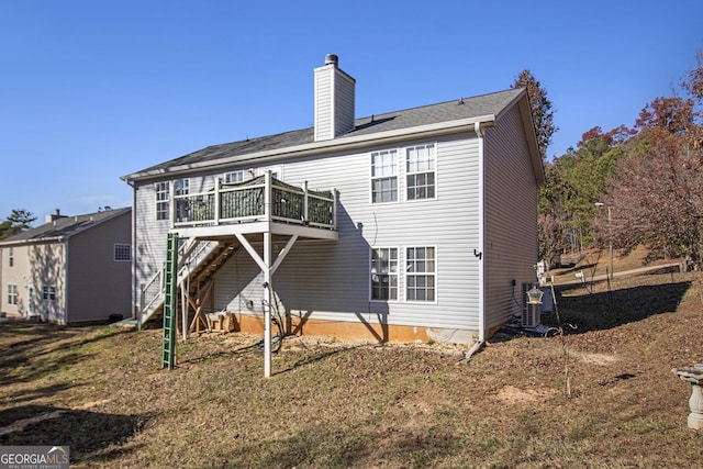 rear view of property featuring a lawn, central AC, and a deck