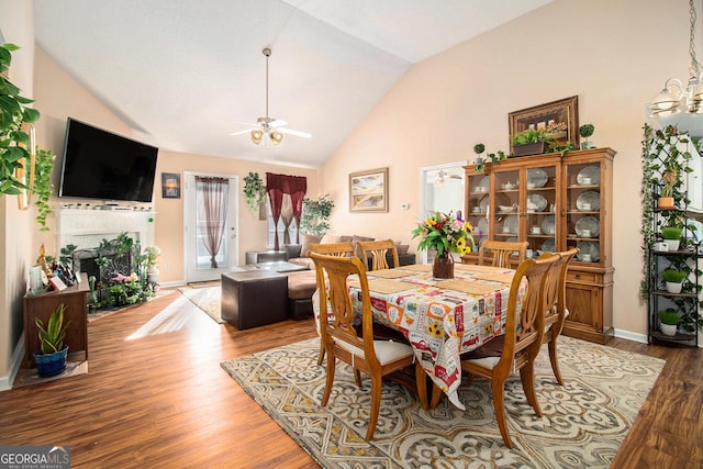 dining area featuring ceiling fan, wood-type flooring, and lofted ceiling