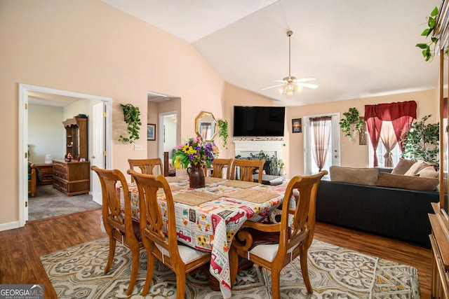 dining room with hardwood / wood-style floors, ceiling fan, and lofted ceiling