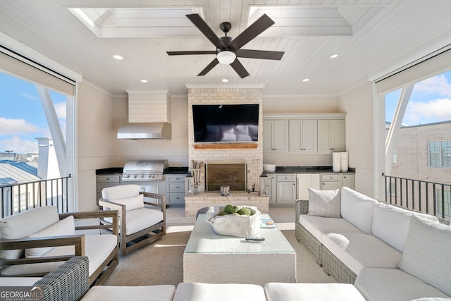 living room featuring a skylight, a brick fireplace, wood ceiling, ceiling fan, and crown molding