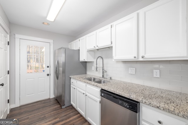 kitchen with light stone countertops, stainless steel appliances, sink, dark hardwood / wood-style floors, and white cabinetry