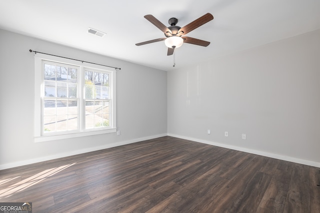 empty room featuring ceiling fan, dark hardwood / wood-style flooring, and a wealth of natural light