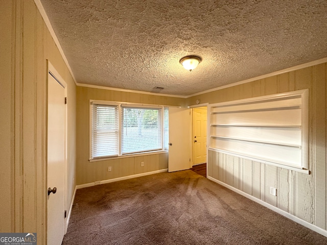 carpeted empty room with ornamental molding and a textured ceiling