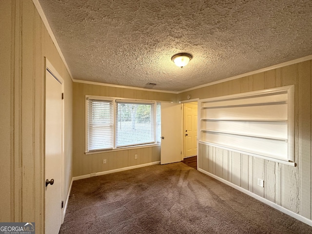 1737 Mckenzie Dr, Decatur, GA 30032 - unfurnished bedroom featuring ornamental molding, a textured ceiling, carpet floors, and wooden walls