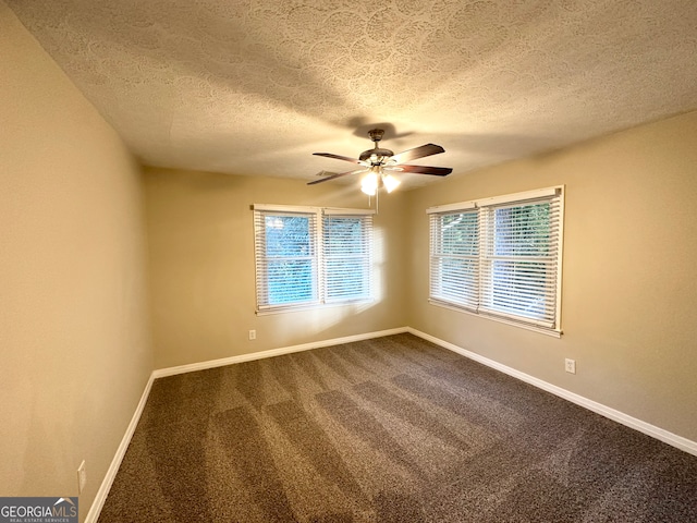 spare room with a textured ceiling, carpet floors, and ceiling fan