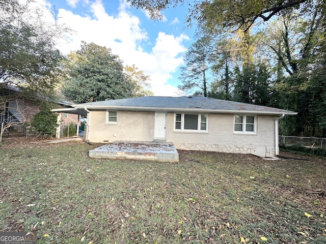 back of house with a carport and a lawn