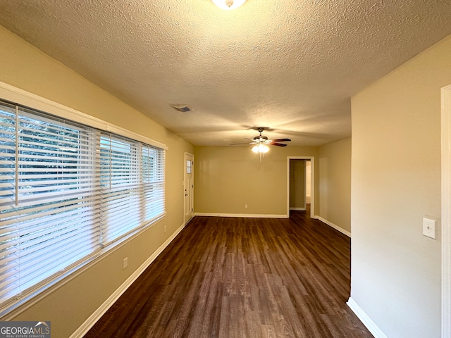 empty room with ceiling fan, dark hardwood / wood-style flooring, and a textured ceiling