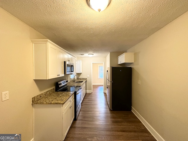 kitchen featuring dark stone counters, white cabinets, sink, dark hardwood / wood-style flooring, and stainless steel appliances