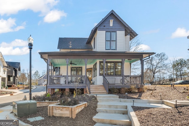 view of front of property with covered porch, ceiling fan, and roof with shingles