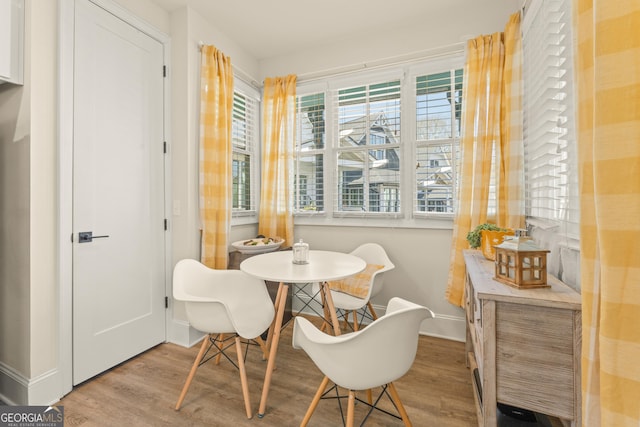 dining area featuring light wood finished floors and baseboards