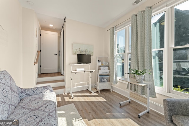 sitting room with a barn door, recessed lighting, visible vents, baseboards, and light wood-type flooring