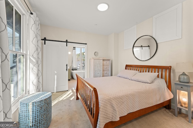 bedroom with light carpet and a barn door