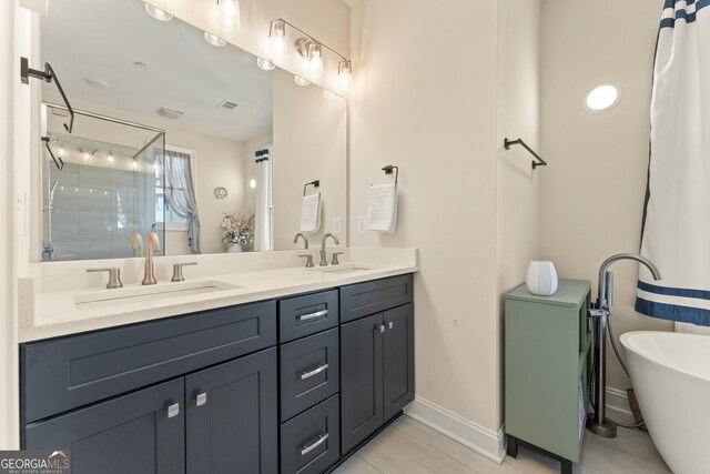 bathroom featuring double vanity, a soaking tub, a sink, and a shower stall