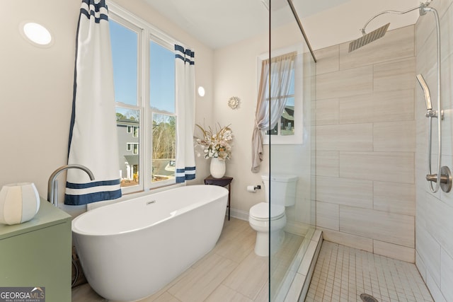 full bath featuring a soaking tub, baseboards, a tile shower, and toilet