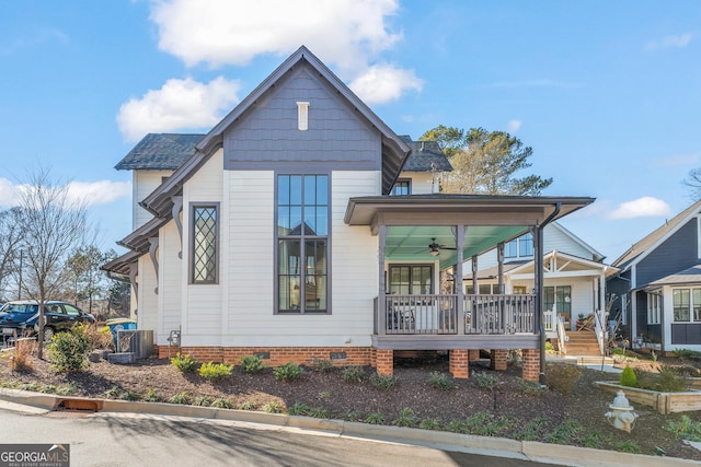 rear view of house featuring crawl space, covered porch, a shingled roof, and a ceiling fan