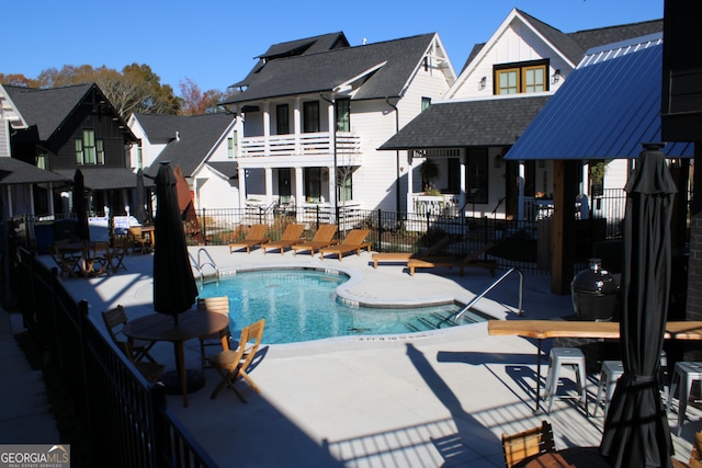 pool featuring a residential view, a patio area, and fence