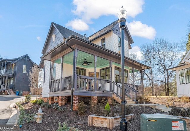 view of front facade with a porch, ceiling fan, a shingled roof, and stairs