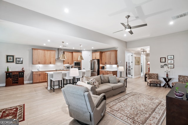 living room with ceiling fan and light wood-type flooring