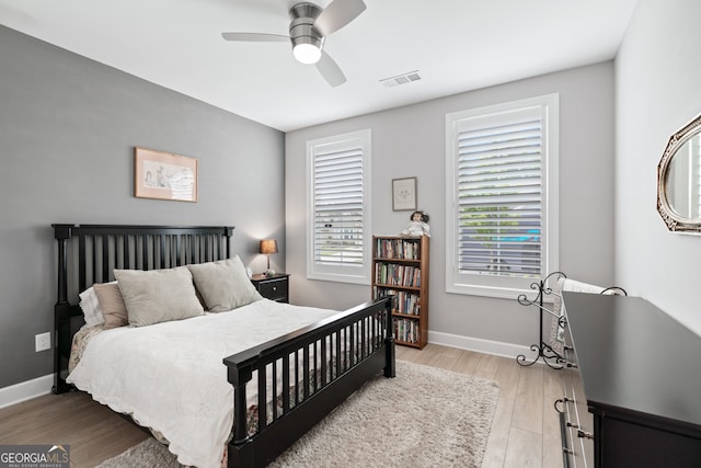 bedroom with light wood-type flooring, multiple windows, and ceiling fan