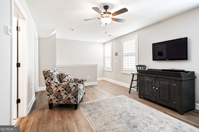 living area featuring ceiling fan and hardwood / wood-style flooring