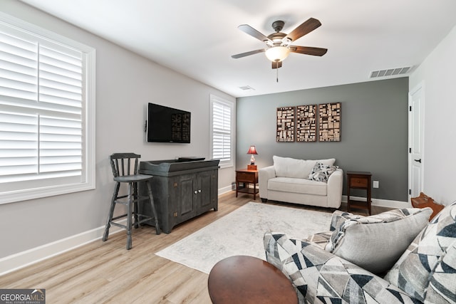 living room featuring ceiling fan and light hardwood / wood-style floors