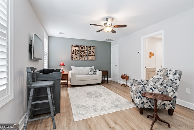 living room with light hardwood / wood-style floors and ceiling fan