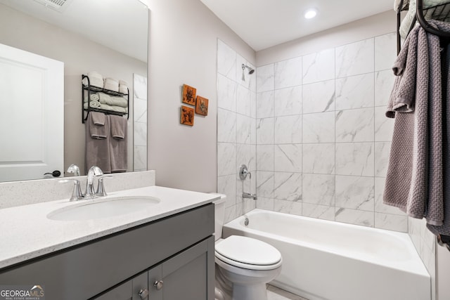 full bathroom with vanity, tiled shower / bath combo, and toilet