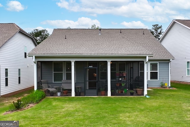 rear view of house featuring a yard and a sunroom