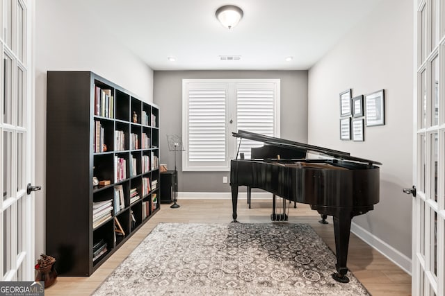 living area with light hardwood / wood-style floors and french doors