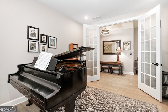 miscellaneous room with french doors, hardwood / wood-style flooring, and an inviting chandelier