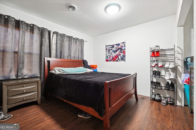 bedroom with dark hardwood / wood-style floors