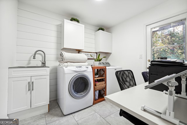 clothes washing area with cabinets, light tile patterned floors, separate washer and dryer, and sink