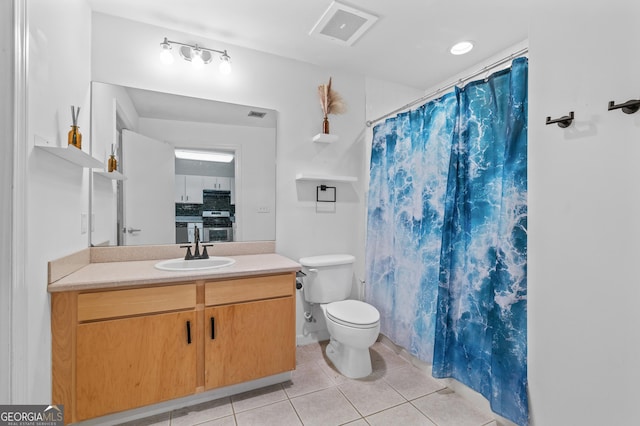 bathroom with toilet, vanity, visible vents, and tile patterned floors