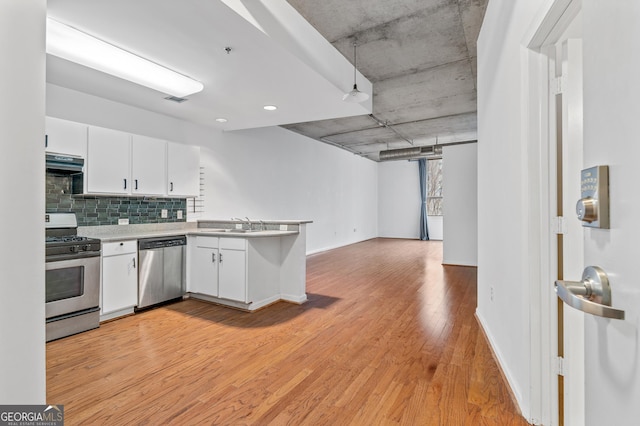 kitchen featuring under cabinet range hood, light wood-style flooring, white cabinetry, and stainless steel appliances