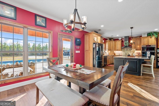 dining room with ornamental molding, dark wood-type flooring, and a notable chandelier