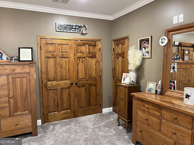 carpeted entrance foyer featuring a textured ceiling and crown molding