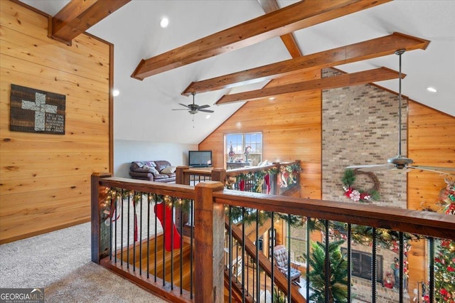 hallway with vaulted ceiling with skylight, carpet floors, and wooden walls