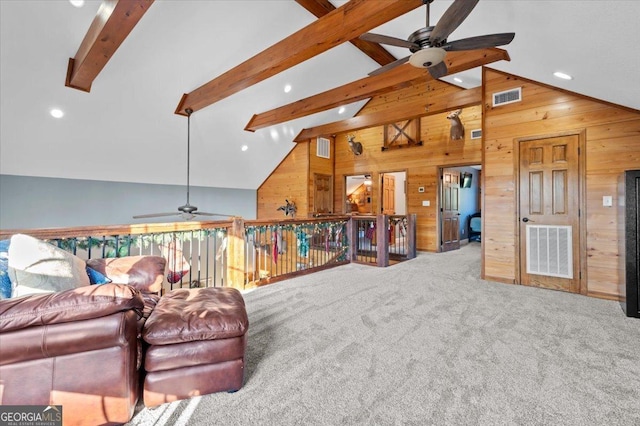 carpeted living room featuring beam ceiling, high vaulted ceiling, ceiling fan, and wood walls