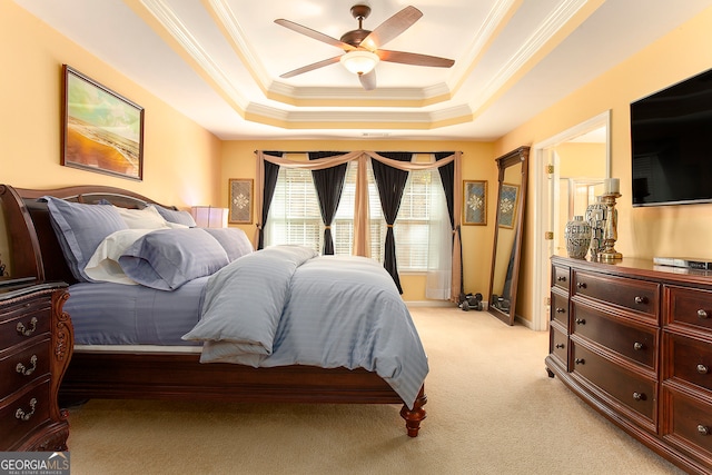 carpeted bedroom featuring a raised ceiling, ceiling fan, and crown molding