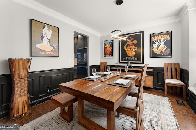 dining space with ornamental molding and dark wood-type flooring