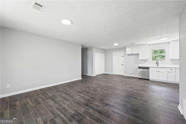 unfurnished living room with dark hardwood / wood-style floors, sink, and a textured ceiling