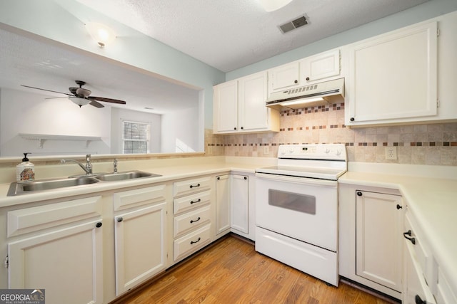 kitchen featuring backsplash, a textured ceiling, sink, white electric range, and light hardwood / wood-style floors