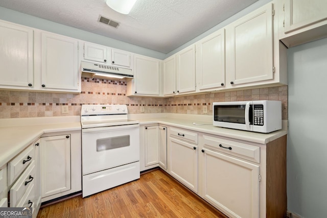 1115 Cannongate Xing SW, Marietta, GA 30064 - kitchen featuring white appliances, under cabinet range hood, light countertops, decorative backsplash, and light wood-style flooring
