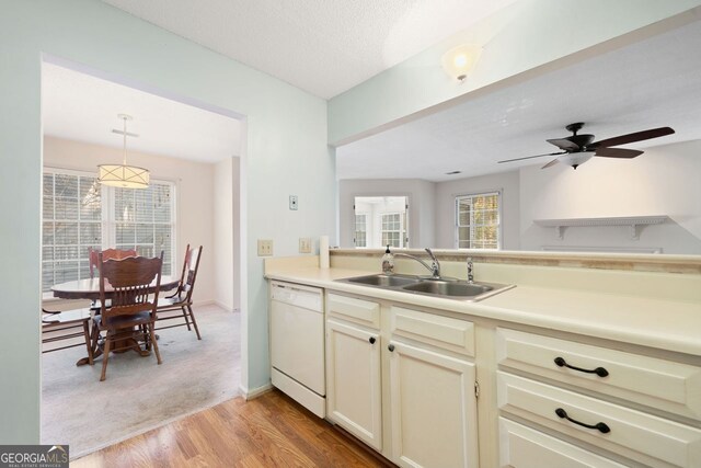 1115 Cannongate Xing SW, Marietta, GA 30064 - kitchen with white dishwasher, light countertops, ceiling fan, decorative light fixtures, and light carpet